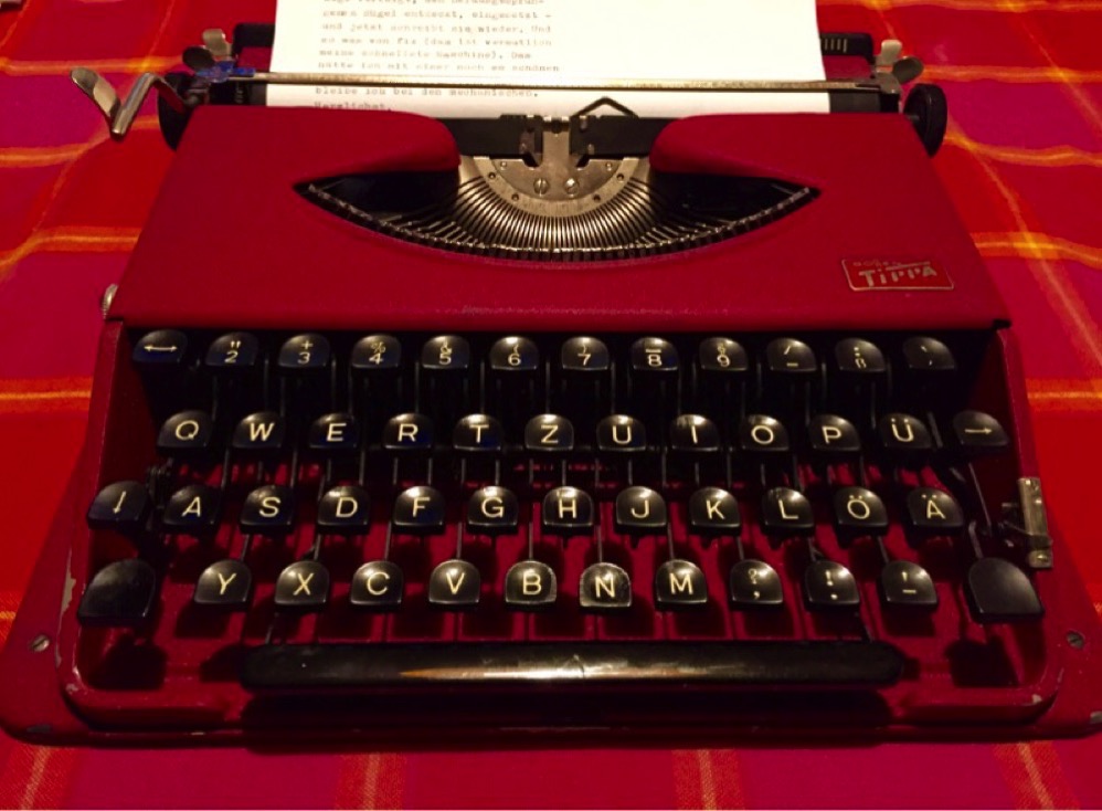 eine rote Tippa-Schreibmaschine steht auf einem Tisch